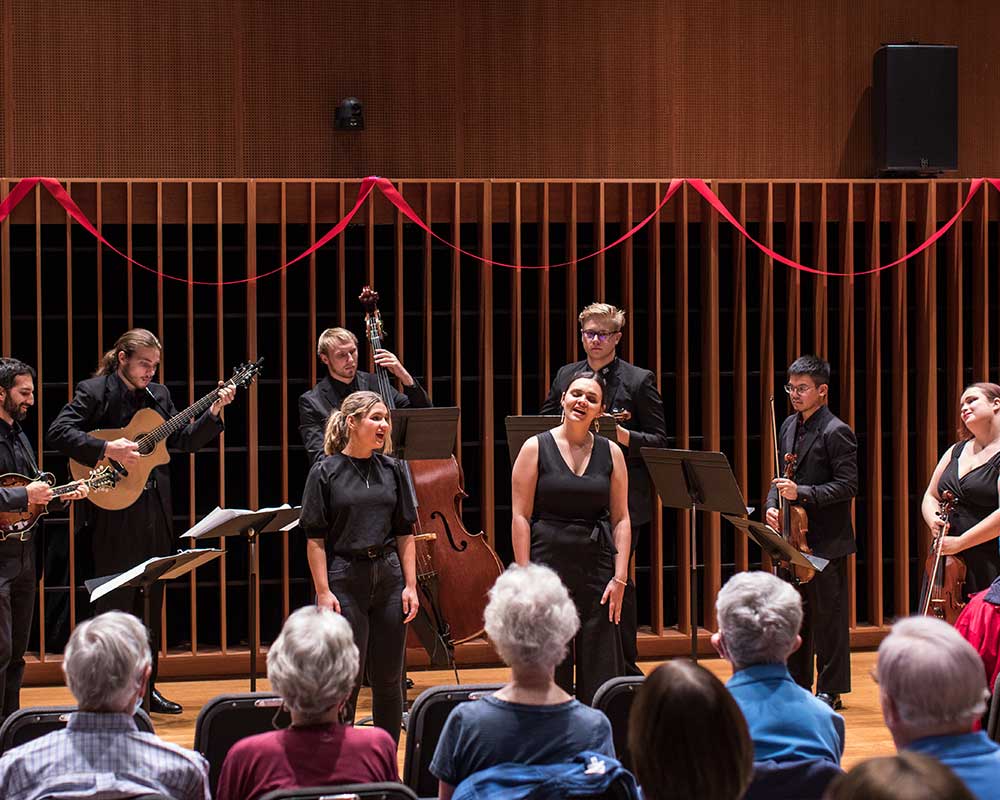 Crowd watching who orchestra playing and singing