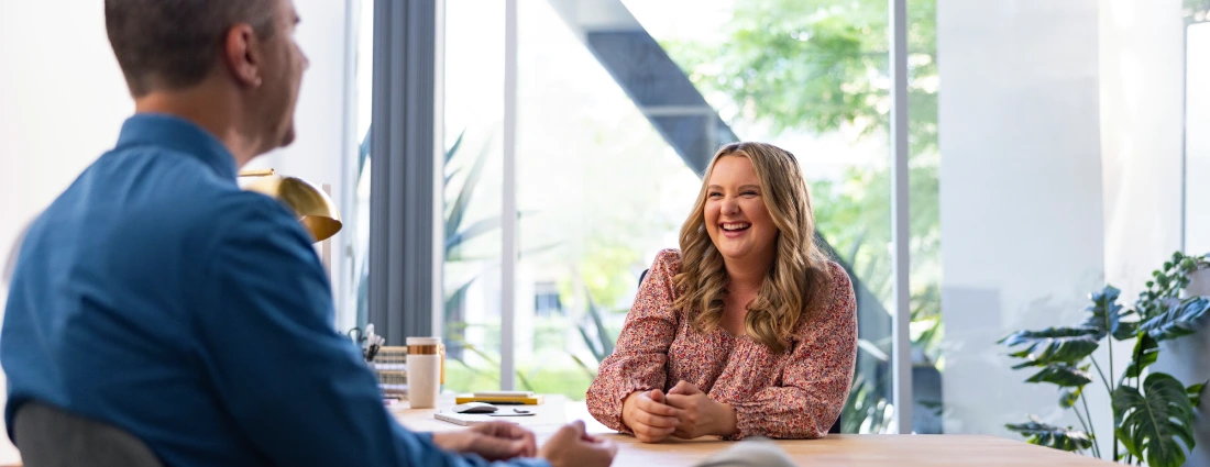 Professional man and woman having a conversation at a desk