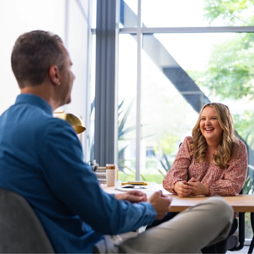 Professional man and woman having a conversation at a desk