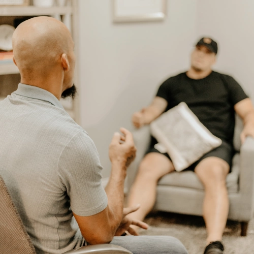 Counseling session between two men in a room