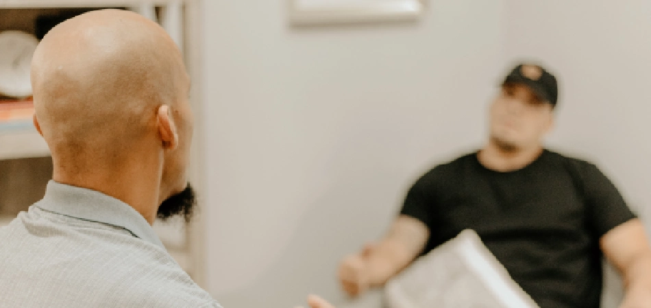 Counseling session between two men in a room