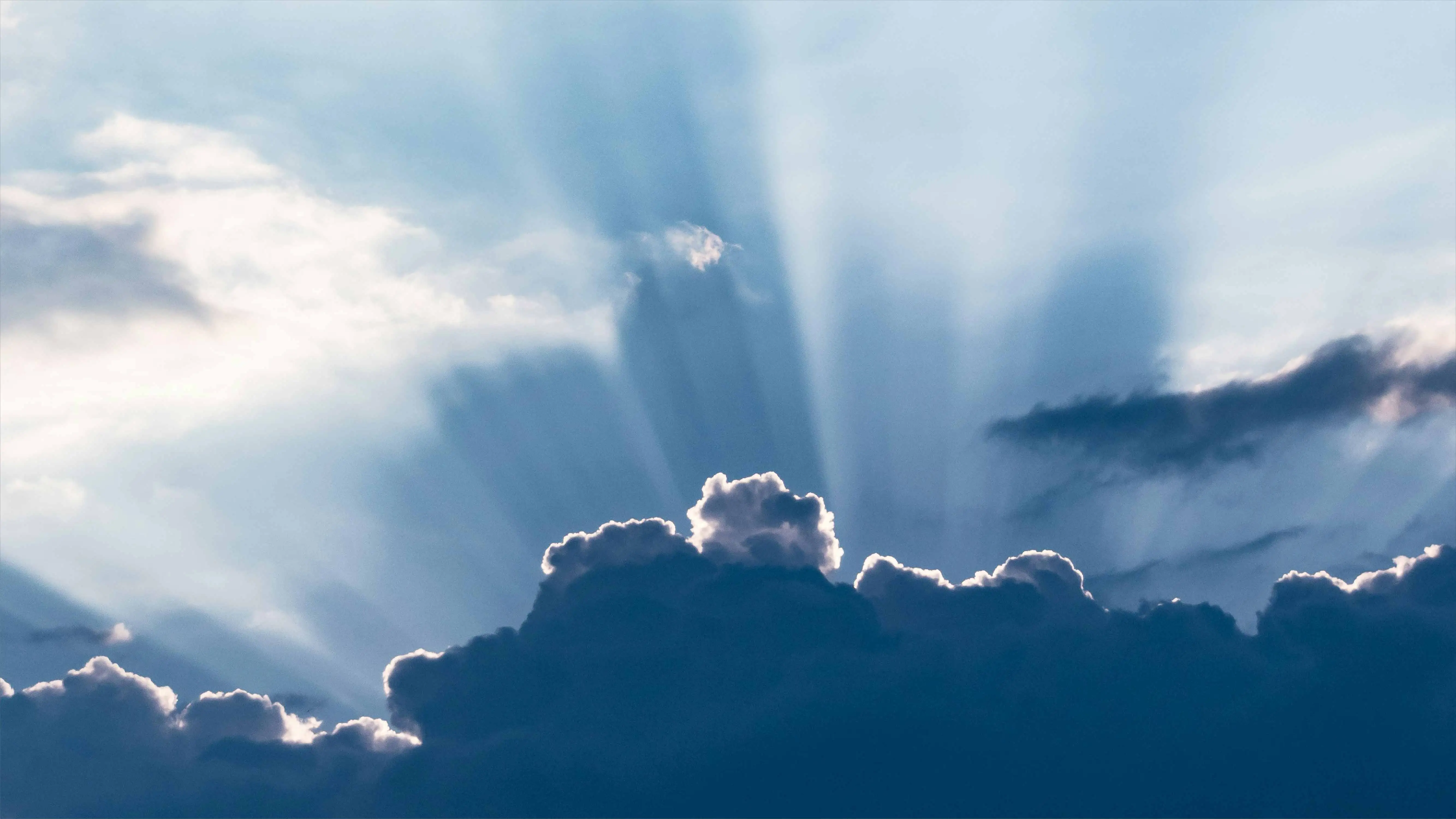 Sky with clouds, sun shining behind the clouds 