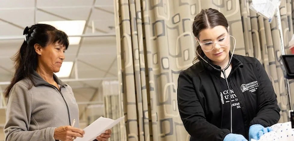 Two nurses exam a patient