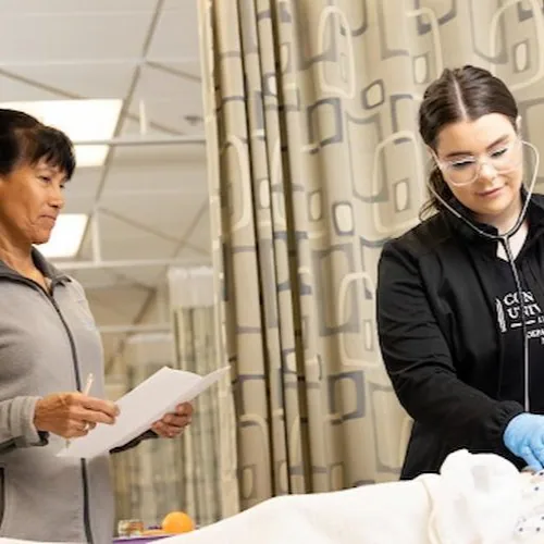 Two nurses exam a patient