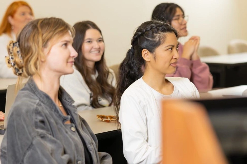 Students attentively listening during a classroom lecture.