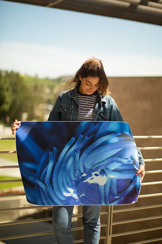 Isabella Jackson standing with one of her photographs